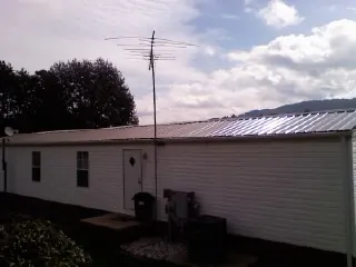 New metal roof on a single wide mobile home with a TV antenna in Mound City